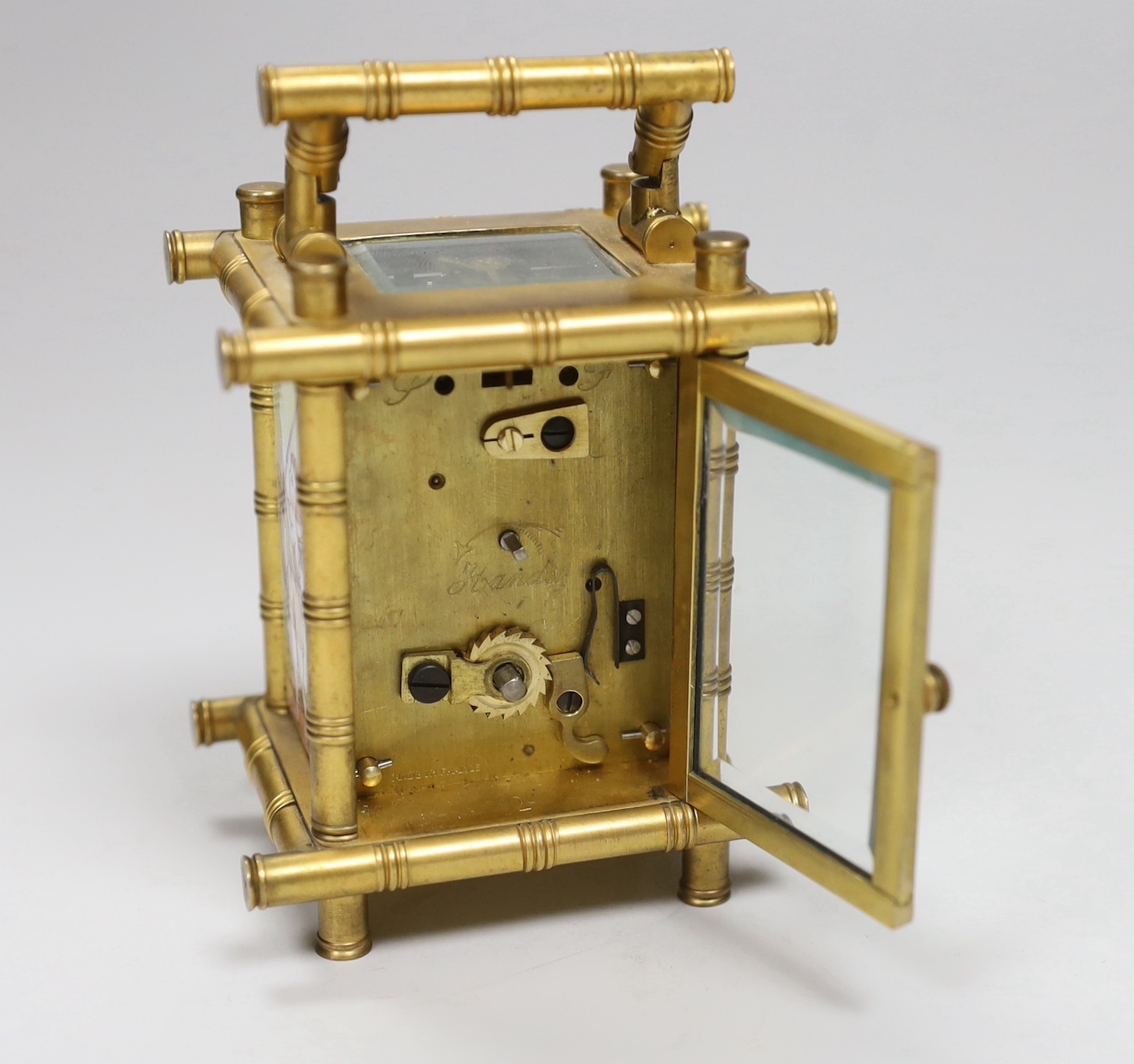 A French bamboo design carriage clock, with three porcelain putti decorated sides, by Elliot & Son, London, 9.5cm high